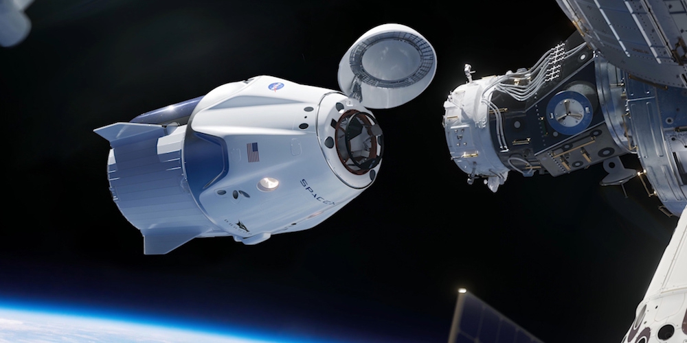 Artistieke impressie van de nieuwe Crew Dragon ruimtecapsule bij het ISS.