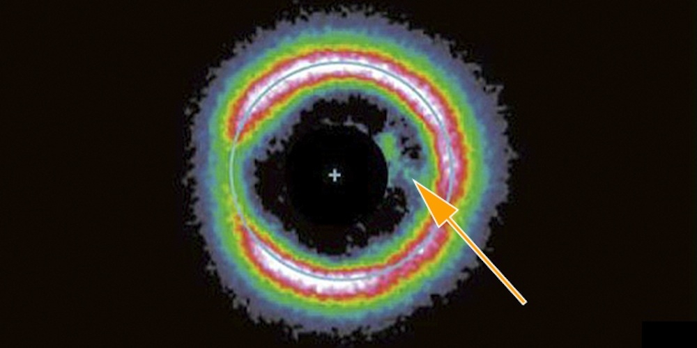 Subaru-opname van de stofschijf rond de jonge ster J1604. De pijl wijst naar de ontdekte stofboog.